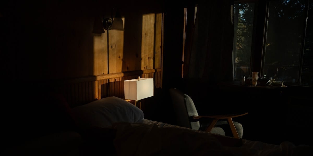 Living cu lumini calde, pături și popcorn pregătit pentru o seară de film acasă