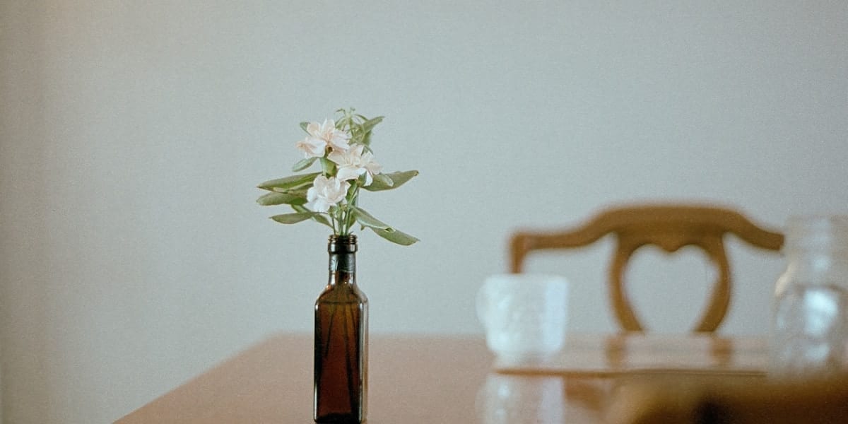 Femeie care își bea cafeaua liniștită lângă fereastră, ilustrând ritmul relaxat al stilului slow living